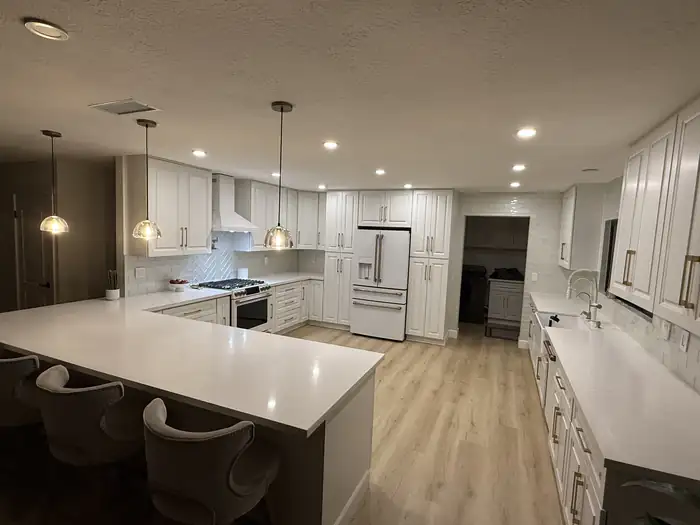 Kitchen with recessed and pendant lighting on, in a home wired by Pelican Coast Electric