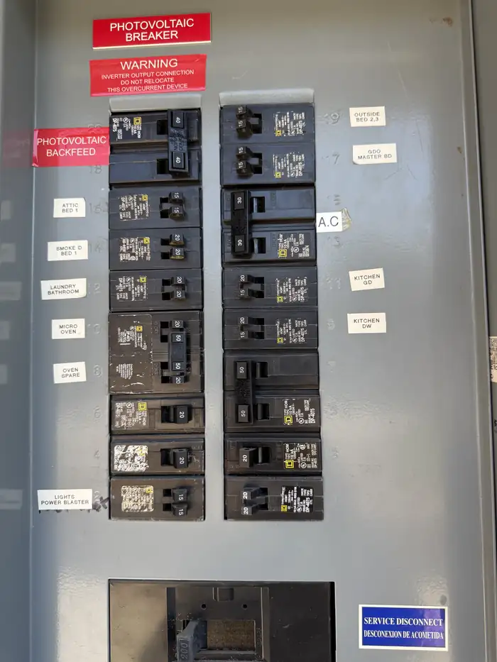 Existing panel interior with hand-labelled breakers before a Pelican Coast upgrade