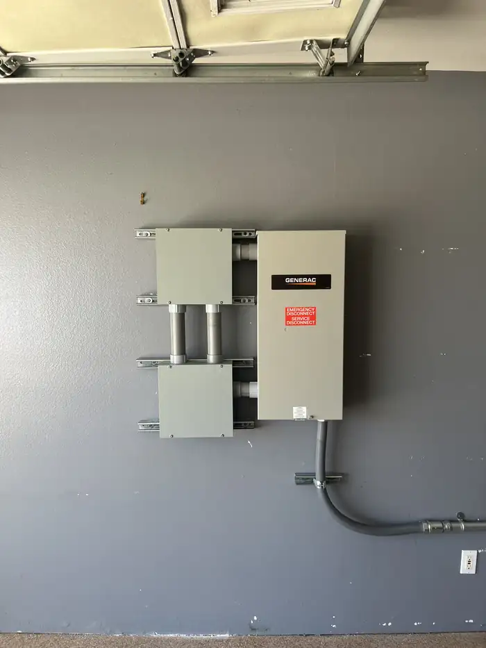 Generac automatic transfer switch mounted in a garage next to the service disconnect